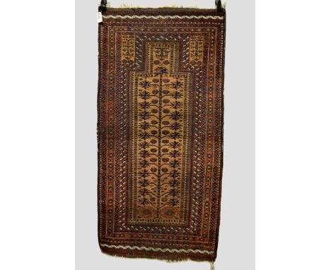 Three Baluchi rugs, Khorasan, north east Persia, all early 20th century, the first a prayer rug with camel field, 5ft. 9in. x