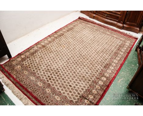 A silk carpet, the beige ground with red subsidiary borders, 216 x 142cm approx. 