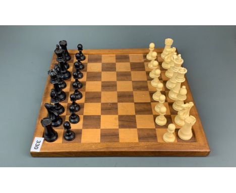A vintage celluloid chess set with wooden board, king H. 9.5cm.