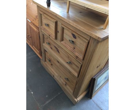 A rustic light wood chest of drawers. 
