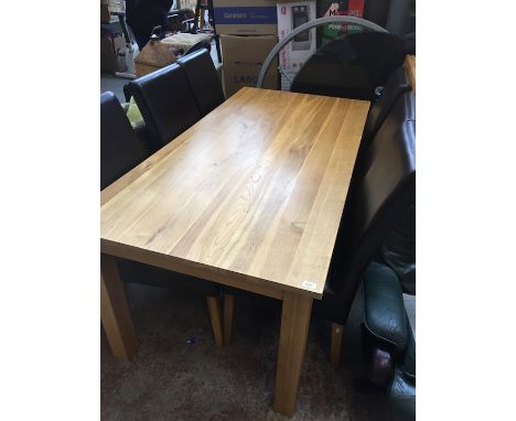 A modern light wood dining table and six leather chairs. 