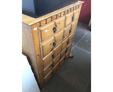 A rustic light wood chest of drawers. 