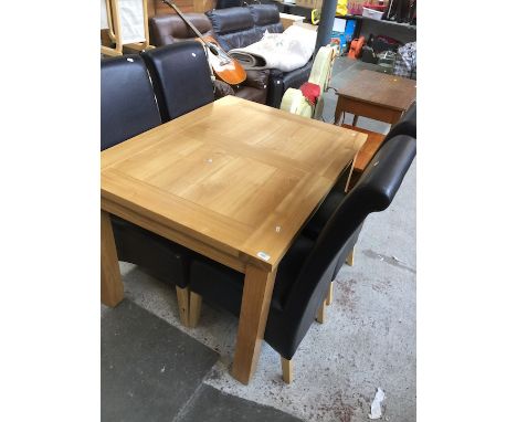 A modern light wood extending table and four chairs. 