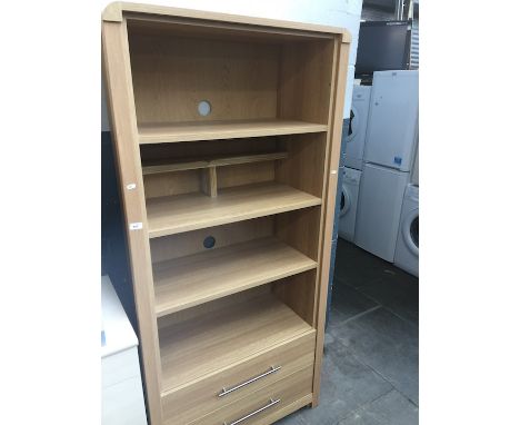 A light oak effect open bookcase with two lower drawers. 