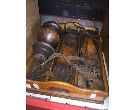 A vintage wooden tray containing a pair of vintage ice skates and a wooden finial 