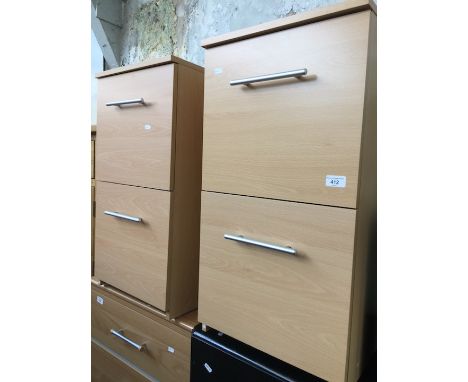 A pair of light wood effect two drawer cabinets. 