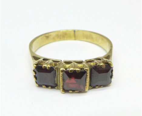 A yellow metal, three stone garnet ring, 3.2g, N