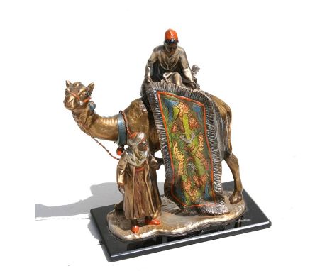 A Bergman style painted spelter table lighter in the form of rug seller and a camel, 18cm (7ins) high 