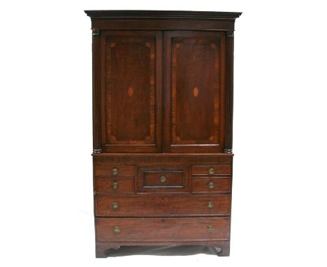 A Georgian mahogany linen press, the pair of inlaid panel doors flanked by reeded columns above an arrangement of four gradua