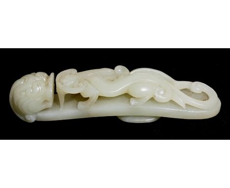 A Chinese jade belt hook decorated with a chilong, with dragon head terminal, 15cms (6ins) long.Condition ReportThere is a ve