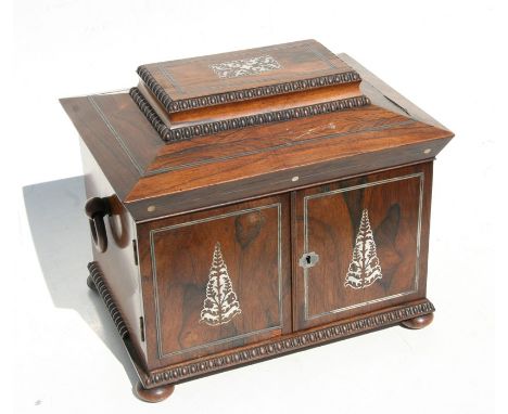 An early 19th century rosewood jewellery box with lift-up lid and fitted interior with two doors enclosing two drawers and on