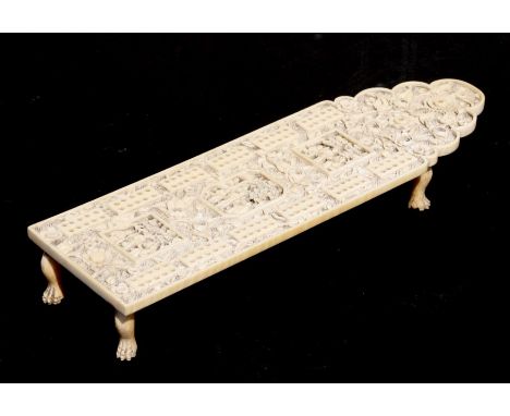 A 19th century Chinese Canton export carved ivory cribbage board decorated with figures within panels with foliate scrolls, 2