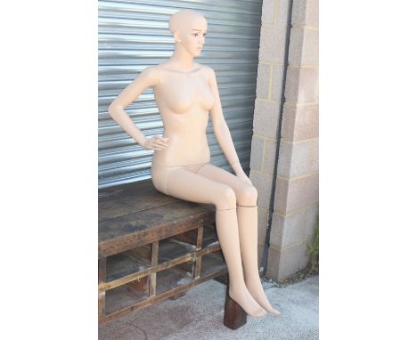 A life size seated female mannequin 