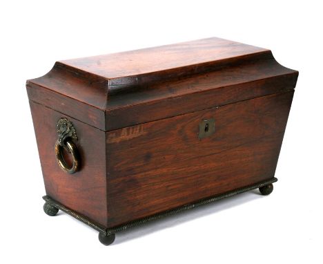 An early 19th century mahogany sarcophagus shaped three division tea caddy, 33cms (13ins) wide.