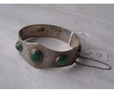 An unusual silver bangle set with  green stones 32g       