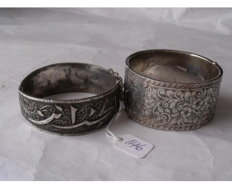 A wide silver engraved bangle also another  white metal example       