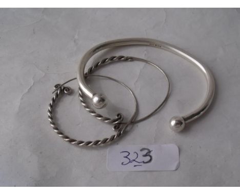 A silver torque bangle and a pair  silver hoop earrings       