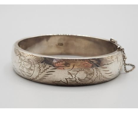 Ladies silver patterned hinged bangle with safety chain 25.2g.