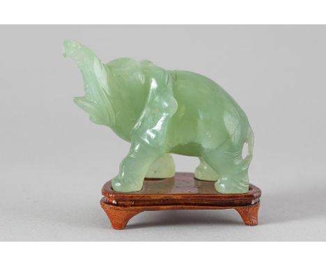 Jade elephant , naturalistic sculpted in light green jade on wooden base , China, Qing Dynasty . 9X11 cm