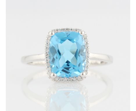 *A blue topaz and diamond cluster ring, set with a rectangular cushion cut blue topaz surrounded by a border of round cut dia