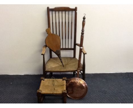 A rush seat stick back nursing chair with bellows, warming pan and string topped stool.