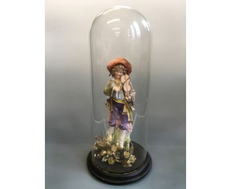 A glass dome covered painted sculpture of boy playing violin. Height approximately 55cm.