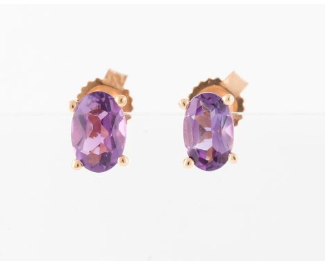 *A pair of amethyst stud earrings, each set with an oval cut amethyst, rose metal stamped 375/1000.
