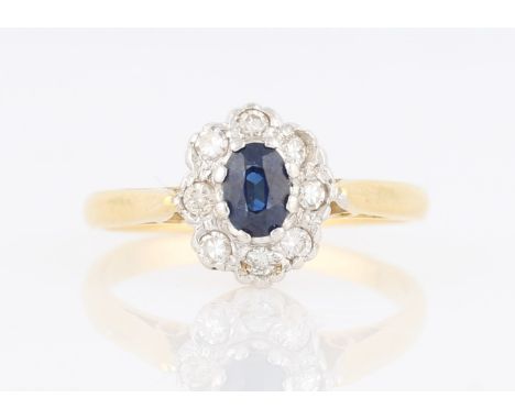 A sapphire and diamond cluster ring, set with an oval cut sapphire, measuring approx. 5x3mm, surrounded by a border of eight 