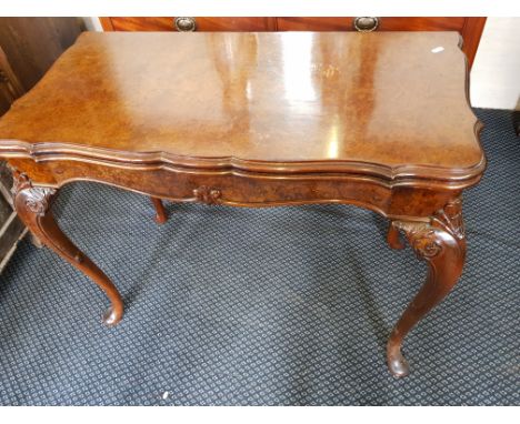 A reproduction walnut card table with cabriole style legs.