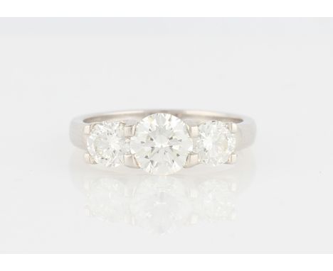 An 18ct white gold three stone diamond ring, set with three graduated round brilliant cut diamonds, central diamond measuring