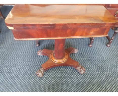 A mahogany Victorian card table with single column and claw feet.