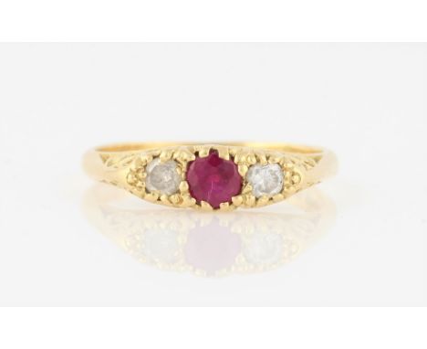 An 18ct yellow gold ruby and diamond three stone ring, set with a central round cut ruby, measuring approx. 4mm, flanked to e