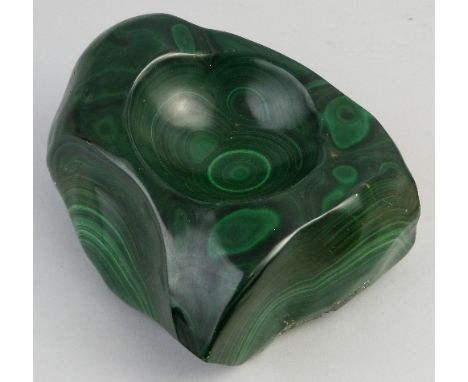 A malachite boulder, of irregular shape, carved as a bowl with a dished centre, approximate weight 6.45kg, 22cm wide