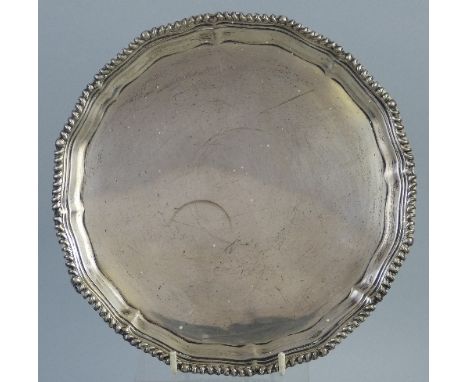 A waiter, of circular form with gadrooned Chippendale moulded rim raised on three scroll feet, 21cm wide, Birmingham 1930, 12