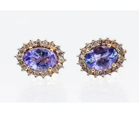 A pair of tanzanite and diamond 9ct gold cluster earrings, comprising claw set with oval tanzanite's, within a border of smal