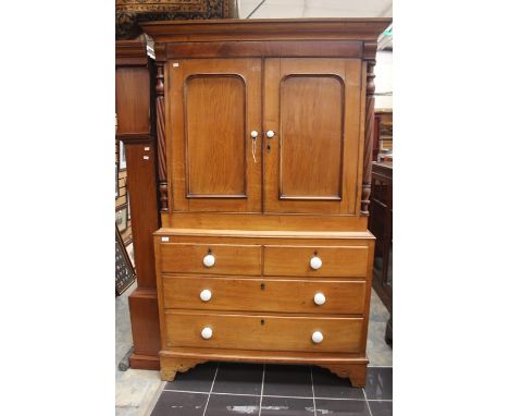An early Victorian oak joined linen press, the upper section with two doors, turned columns, with two short over two long Dra