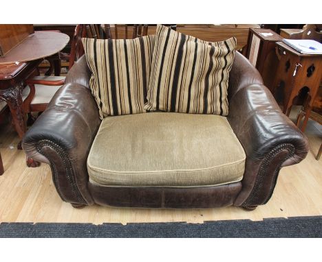 Brown leather small two seater sofa with studded arms, shabby looking leather fabric seats.