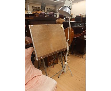 An artist's drawing board, folding mechanism, together with a Photax artist standard lamp, adjustable stand.