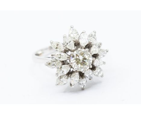 A diamond set platinum cluster ring, the cental brilliant cut diamond approx. 1 carat inset within a surround of marquise cut