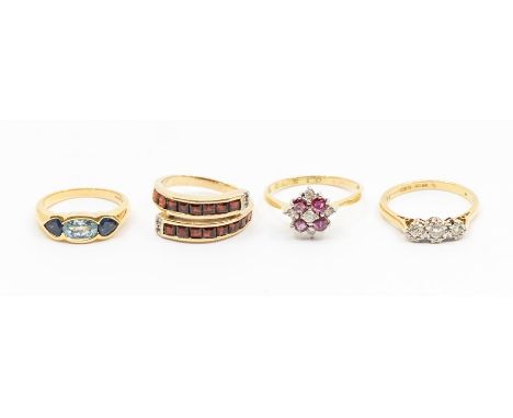 A collection of four gold stone set rings to include a diamond and 18ct three stone ring, size N1/2, a ruby and diamond 18ct 