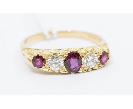 A ruby and diamond 18ct gold boat head ring, comprising an oval central ruby, set either side by a brilliant cut diamond, eac