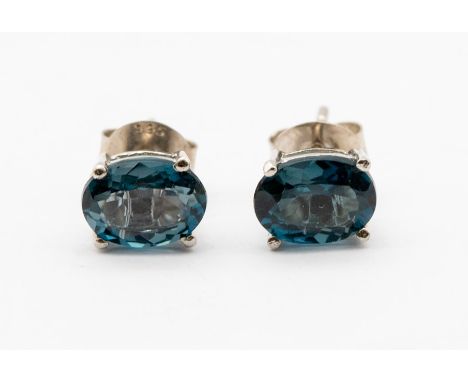 A pair of London blue topaz silver stud earrings, claw set with oval stones approx 8 x 6mm, post and scroll pierced fittingsC
