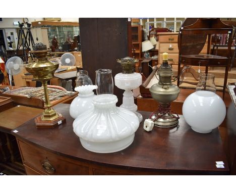 Three oil lamps, comprising of an Edwardian brass hexagonal shaped oil lamp with glass shade and a mahogany frame, an Art Nou