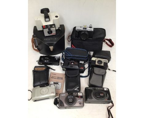 A collection of assorted cameras, including Roniflex, Halina camera, Polaroid, plus many more.