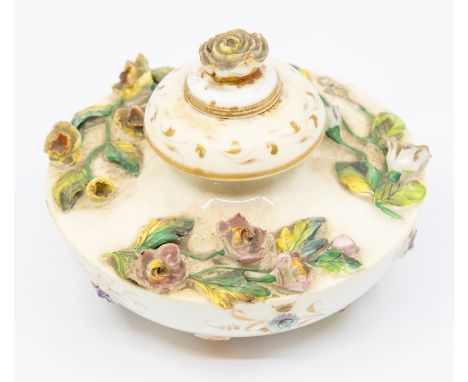 An early 19th Century Rockingham circular inkwell and stopper, the body applied with flowers, the underside applied with flor