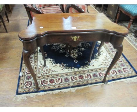 A GEORGIAN MAHOGANY FOLD OVER CARD TABLE the rectangular top with eared corners and frieze drawer on cabriole legs with pad f