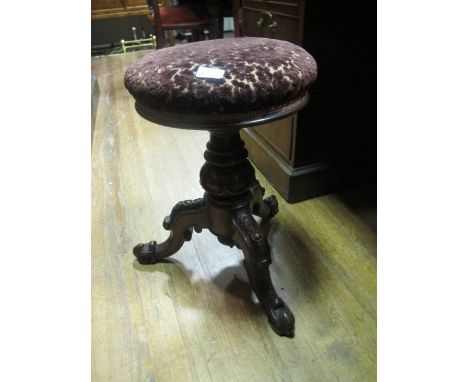 A VICTORIAN MAHOGANY MUSIC STOOL the upholstered adjustable seat above a baluster column on tripod support with scroll toes