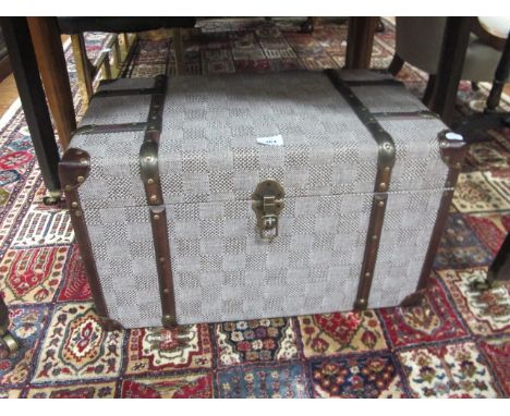 A SMALL UPHOLSTERED TRAVELLING TRUNK with strap hinges