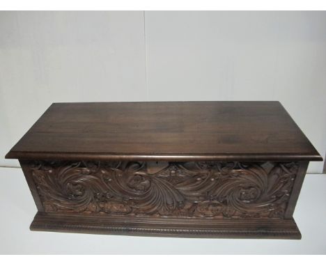 A WALNUT TRUNK the rectangular hinged lid above a foliate carved frieze 47cm (h) x 125cm (w) x 48cm (d)
