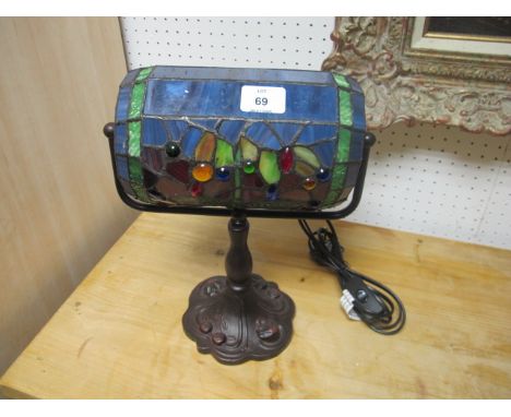 A TIFFANY STYLE ETCHED GLASS TABLE LAMP with multicoloured glass shade above a baluster column on  spreading foot 32cm high 